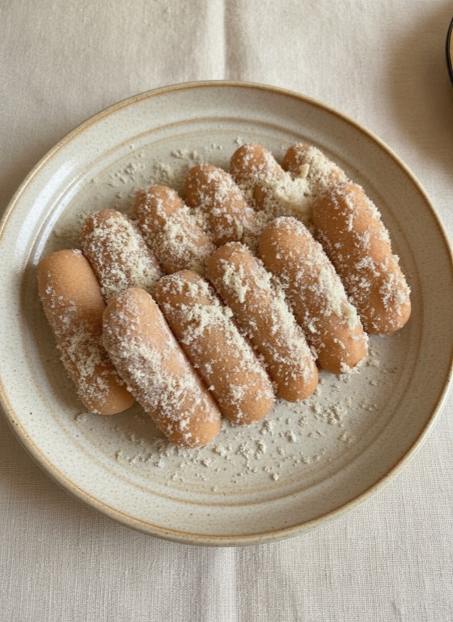 Our chomchom — golden milk sweets dusted with khoya, on a ceramic plate